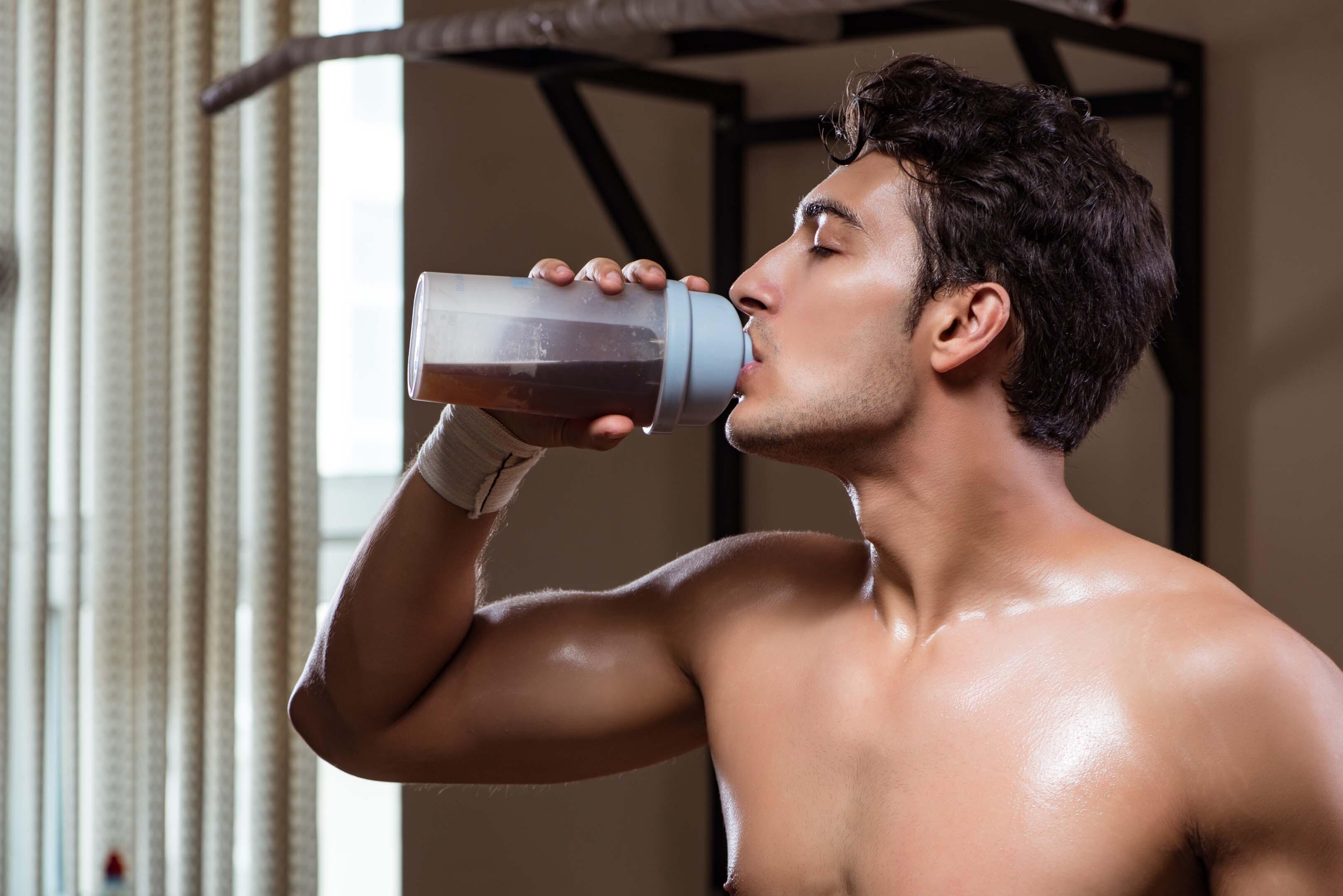 A person drinking a glass of Animal Primal Pre Workout with its absorption and nutrient enhancers